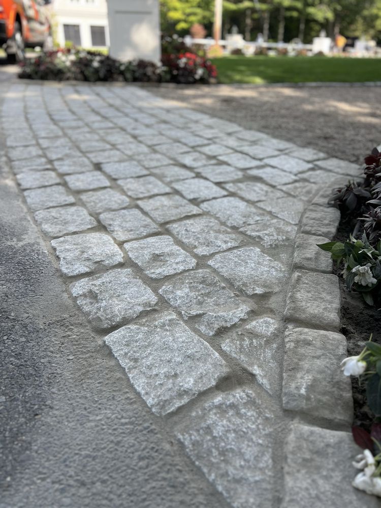 Walkway in reclaimed granite cobblestone, set tight with planted borders